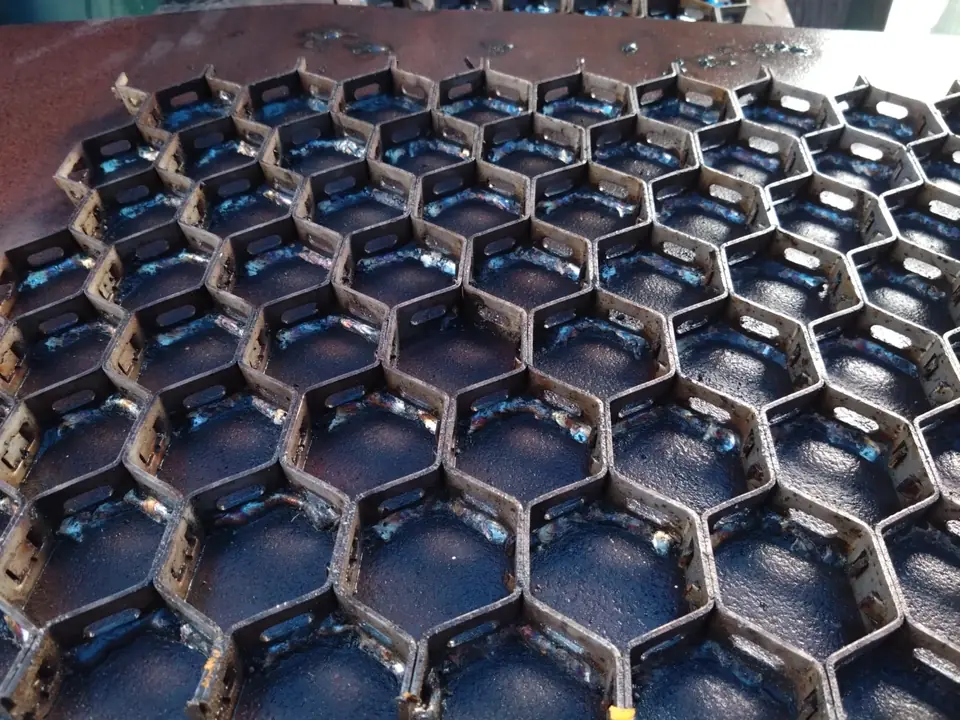 Hexmesh anchorage welded to a steel surface, ready for refractory placement